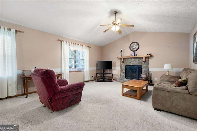 living room featuring vaulted ceiling, ceiling fan, a fireplace, and carpet floors