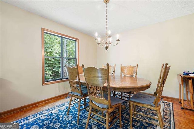 dining space featuring parquet floors and an inviting chandelier