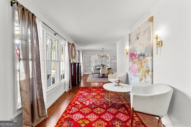 interior space featuring an inviting chandelier, crown molding, and hardwood / wood-style flooring