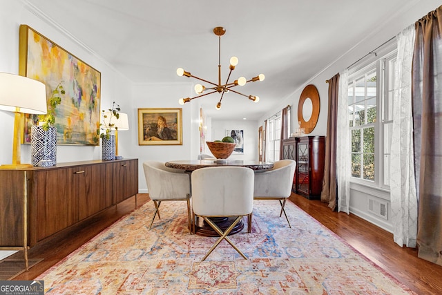 dining room featuring dark hardwood / wood-style flooring, crown molding, a notable chandelier, and a healthy amount of sunlight