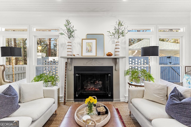 living room featuring wooden ceiling, ornamental molding, and plenty of natural light