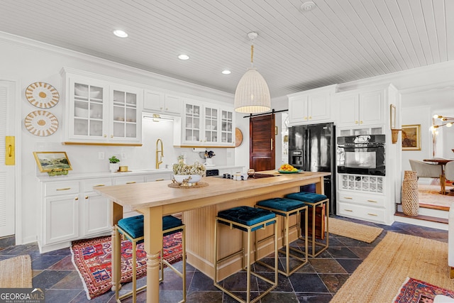 kitchen with wood ceiling, white cabinets, a breakfast bar, and black appliances