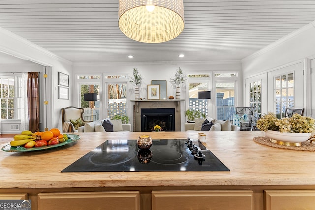 kitchen featuring a healthy amount of sunlight, wooden counters, crown molding, and black electric cooktop