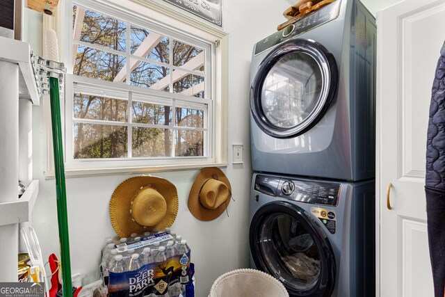 clothes washing area featuring a healthy amount of sunlight and stacked washer and dryer