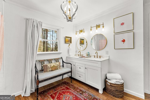 bathroom featuring hardwood / wood-style flooring, vanity, crown molding, and an inviting chandelier