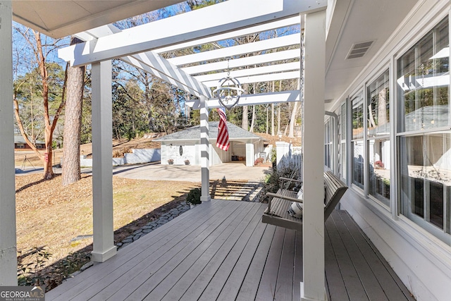 wooden deck with a pergola, a patio area, and an outdoor structure