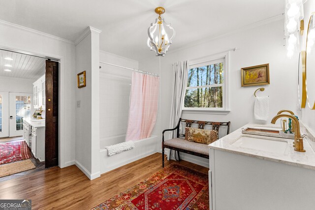 living area featuring french doors, dark wood-type flooring, sink, and ornamental molding