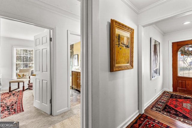 foyer featuring light colored carpet and ornamental molding