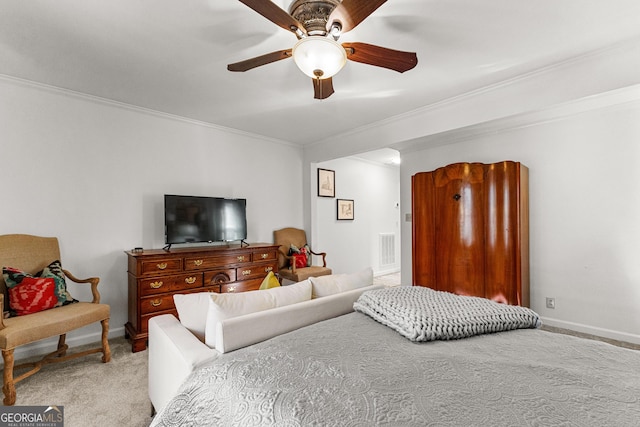 carpeted bedroom with ceiling fan and ornamental molding