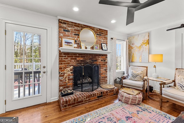 sitting room with crown molding, a fireplace, and wood-type flooring