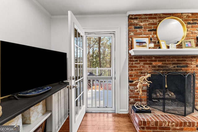 living room featuring hardwood / wood-style flooring, ornamental molding, french doors, and a fireplace