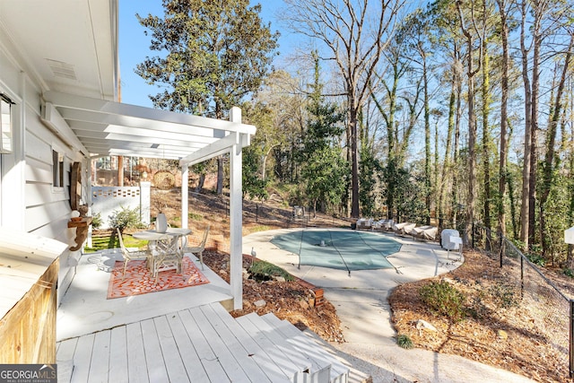 wooden deck with a pergola, a patio area, and a covered pool