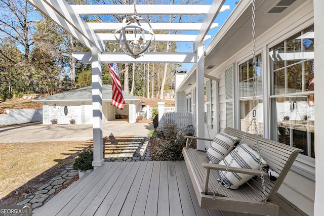 wooden deck featuring a pergola and an outdoor structure