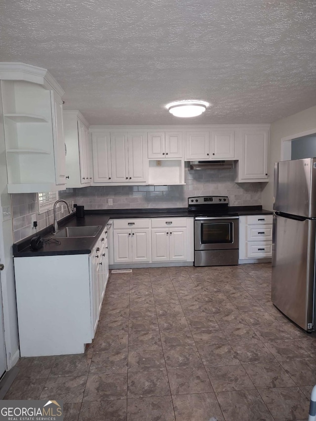 kitchen featuring stainless steel appliances, sink, decorative backsplash, and white cabinets