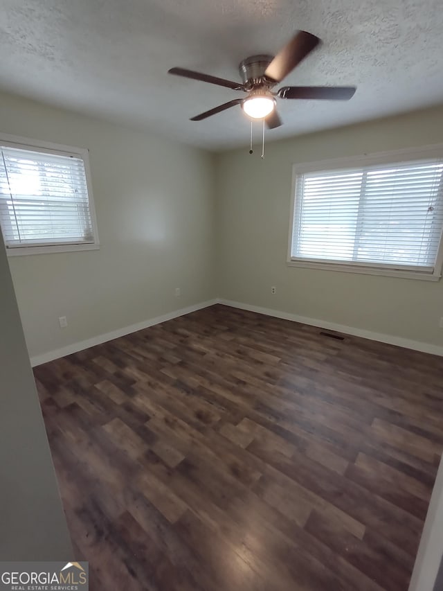 spare room with ceiling fan, dark hardwood / wood-style floors, and a textured ceiling