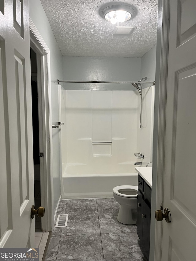 full bathroom featuring vanity, shower / bathing tub combination, toilet, and a textured ceiling