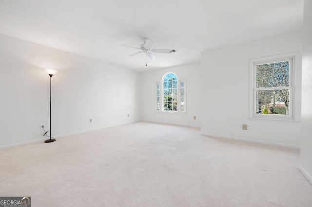 spare room with ceiling fan and light carpet