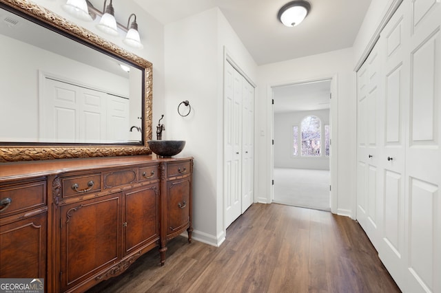 corridor with sink and dark hardwood / wood-style floors