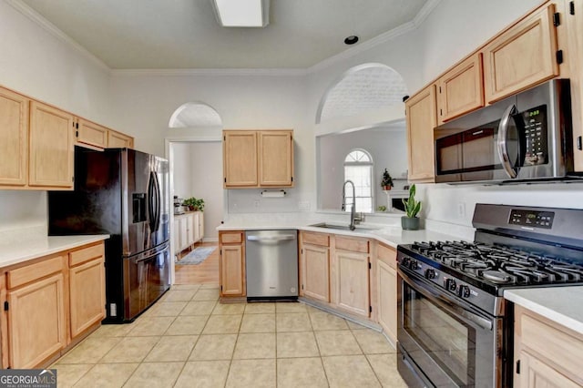 kitchen featuring stainless steel appliances, light brown cabinetry, ornamental molding, and sink