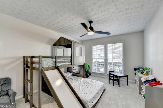 carpeted bedroom featuring a textured ceiling and ceiling fan