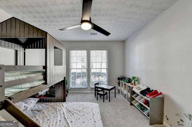 carpeted bedroom featuring a textured ceiling and ceiling fan