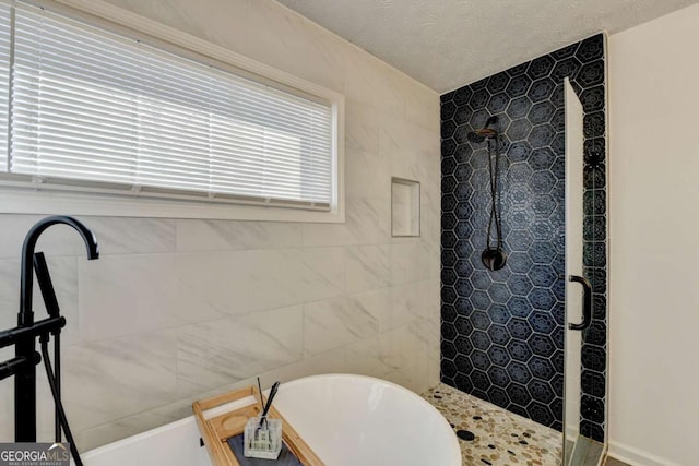 bathroom with separate shower and tub and a textured ceiling