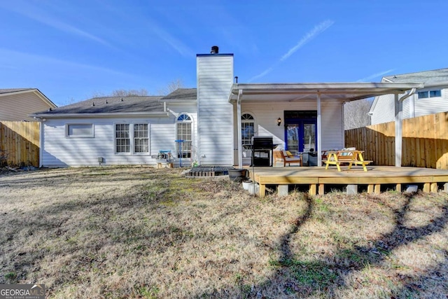 back of house featuring a yard and a wooden deck