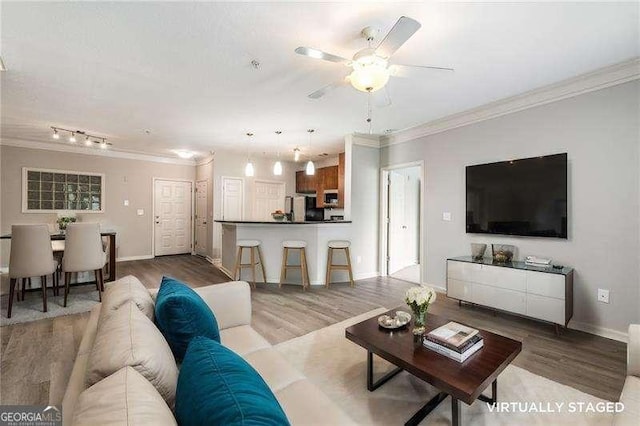 living room featuring ceiling fan, crown molding, and hardwood / wood-style flooring