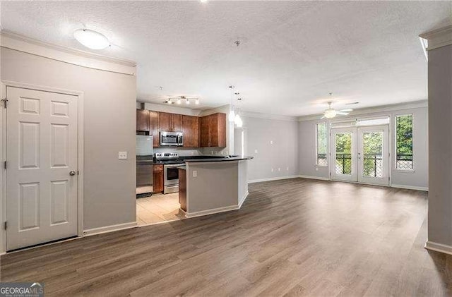 kitchen featuring ceiling fan, hardwood / wood-style flooring, hanging light fixtures, stainless steel appliances, and ornamental molding