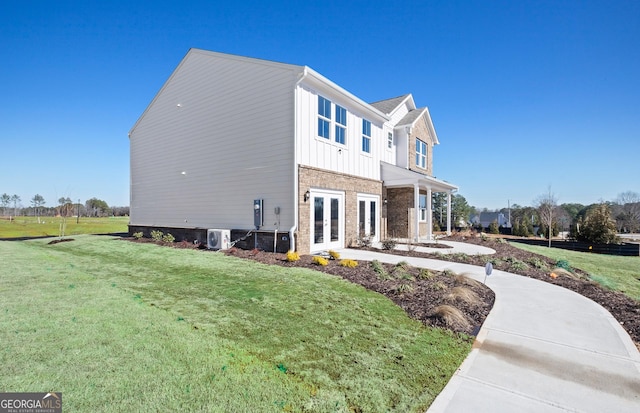 view of side of home featuring a yard and french doors