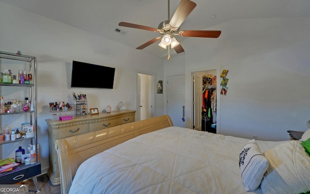 bedroom with ceiling fan, a spacious closet, a closet, and vaulted ceiling