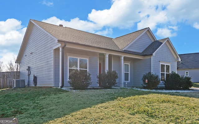 view of front of house featuring cooling unit and a front lawn