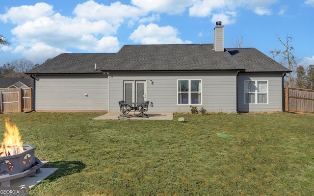 back of house featuring an outdoor fire pit, a lawn, and a patio