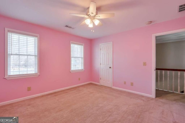 unfurnished bedroom with ceiling fan, light colored carpet, and multiple windows