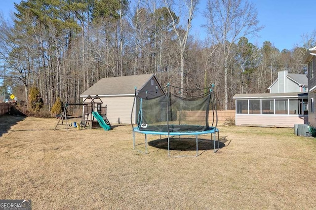 view of yard featuring a playground, a sunroom, and a trampoline