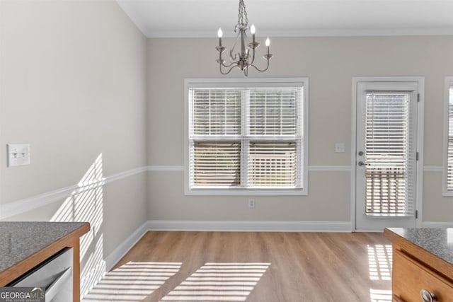 dining area with crown molding, light hardwood / wood-style floors, and a notable chandelier