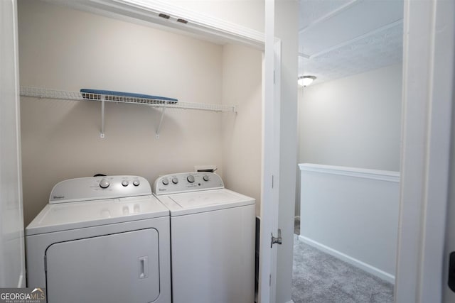 laundry room featuring washing machine and dryer and light colored carpet