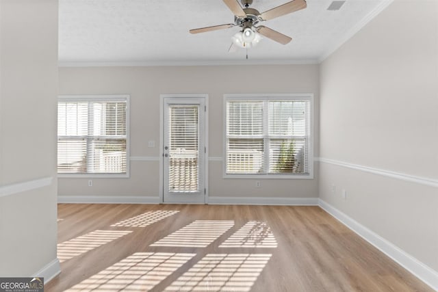 interior space with ceiling fan, plenty of natural light, crown molding, and a textured ceiling