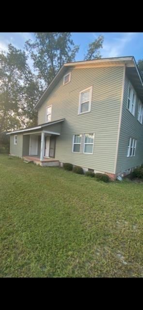 rear view of property featuring a lawn