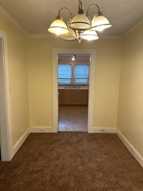 unfurnished dining area featuring dark carpet, ornamental molding, a notable chandelier, and a textured ceiling