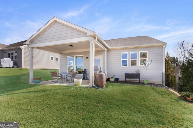 rear view of house featuring a lawn and a patio