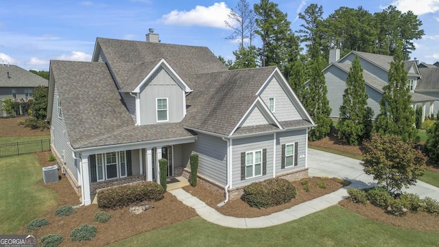 view of front of home with central AC, a porch, and a front yard