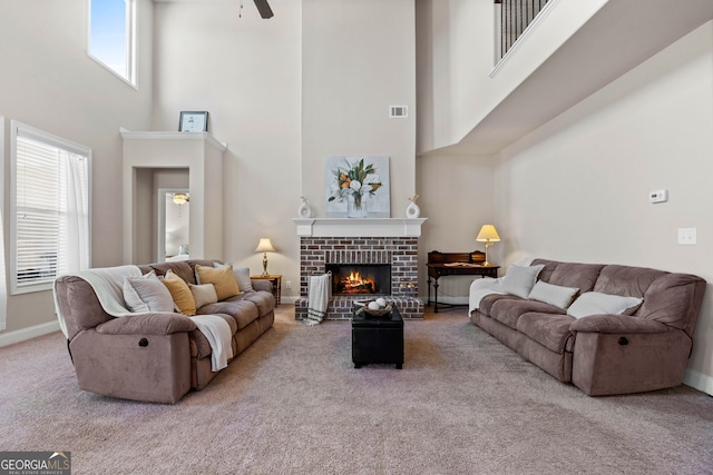 living room with carpet floors, a brick fireplace, visible vents, and plenty of natural light