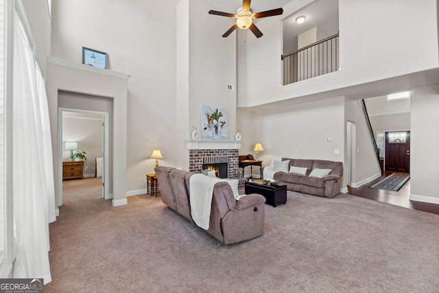 living area with a brick fireplace, carpet, and baseboards