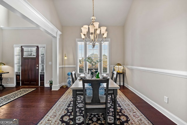 dining room with dark wood-style flooring, vaulted ceiling, baseboards, and an inviting chandelier