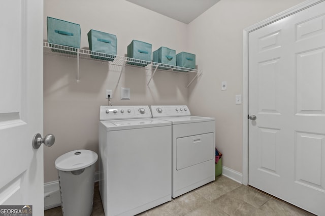 washroom featuring laundry area, baseboards, and washing machine and clothes dryer