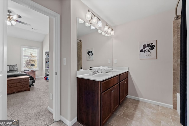 full bathroom featuring a sink, double vanity, baseboards, and connected bathroom