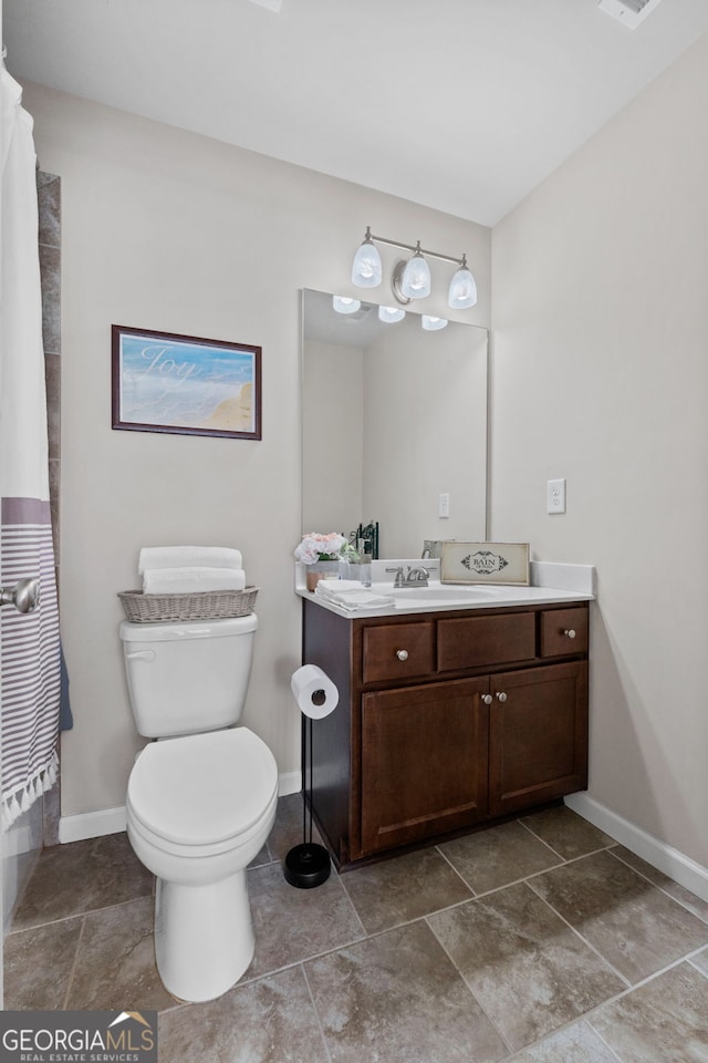 bathroom featuring a shower with shower curtain, vanity, toilet, and baseboards