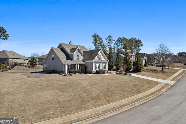 view of front of property featuring a chimney, fence, and a residential view