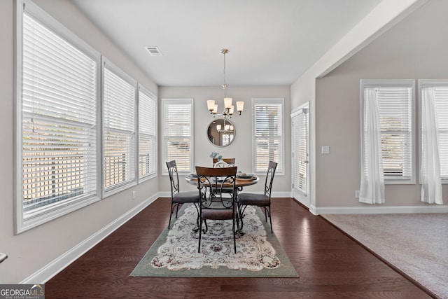 dining room with an inviting chandelier, baseboards, and dark wood-type flooring